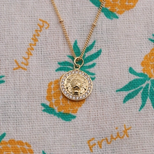 Collier doré avec pendentif tête de lion et cristaux de zircon étincelants