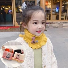 Close-up of yellow knitted turtleneck scarf with cute deer patch for kids