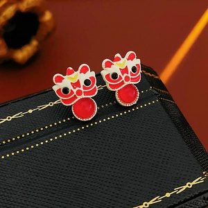 Detailed shot of traditional Chinese lion earrings with red enamel and bead accents