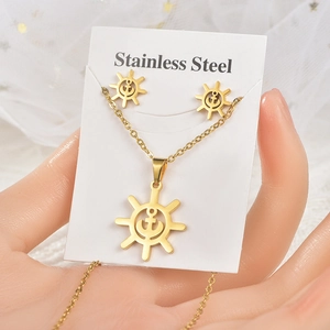 Close-up of golden stainless steel jewelry set featuring anchor and helm nautical charms