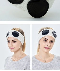 Detail view of white knitted headband with integrated black goggle lenses and soft wool texture