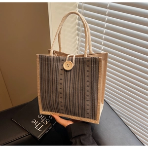 Detail of vintage striped linen tote bag with rope handles and large wooden button