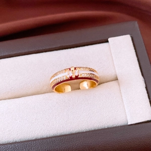 Detail of 18k gold plated ring with fleur-de-lis pattern and red enamel inlay