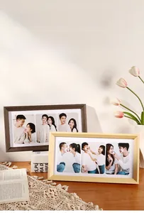 Three-opening rectangular wooden photo frame displaying three landscape pictures on a desk