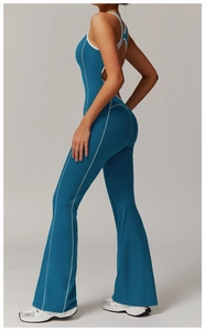 Detail-Seitenansicht des Yoga-Jumpsuits in Petrol mit weißen Kontrastnähten und Schlaghose