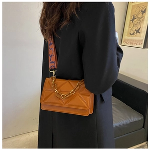 Detail of orange crossbody bag with 3D triangle pattern and dual color wide strap