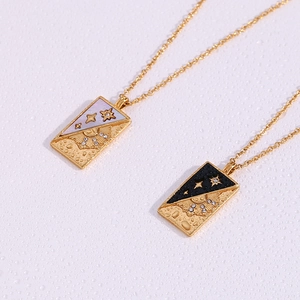 Close-up of gold tarot pendant necklace featuring sun and star motifs with crystal accents