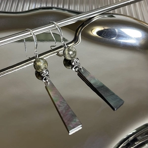 Long drop earrings with pyrite stone and black mother of pearl shell on silver tray