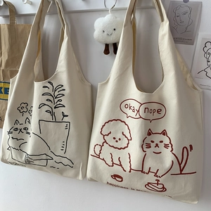 Detail of canvas tote bags with cute cat and dog illustrations and healing text motifs