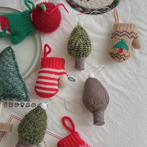 Festive collection of knitted Christmas ornaments featuring trees and gloves on white background