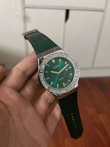 Detailed macro view of the green sunray dial and rhinestone-encrusted bezel of the quartz watch