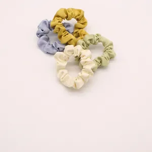 Set di quattro elastici in chiffon color pastello blu, giallo, verde e beige su bianco
