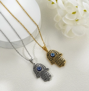 Detail of Hamsa Hand necklaces in gold and silver with blue Evil Eye beads and engravings