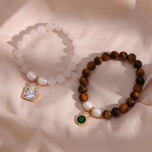Detailed shot of tiger eye stone beads and white crystal bracelets with gold charms