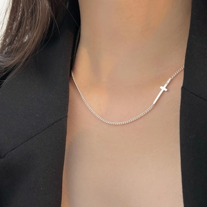 Close-up of a minimalist 925 sterling silver horizontal cross choker on a model neckline