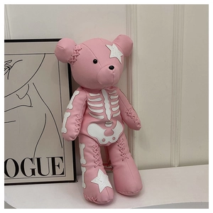 Detailed view of pink bear backpack with skeletal patches and ribbon lace-up decorations