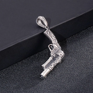Macro shot of vintage punk revolver pistol pendant with detailed floral engraving on steel