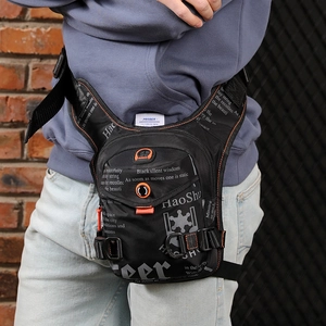 Tactical black drop leg bag with white lettering and orange details on street style model