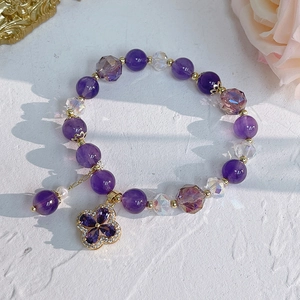 Detail of natural amethyst bracelet with gold clover pendant and cubic zirconia accents