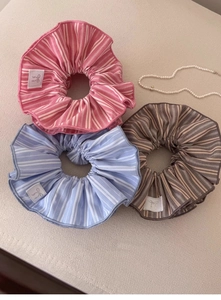 Vue à plat de chouchous en tissu rayé rose, bleu clair et marron avec étiquettes nœud