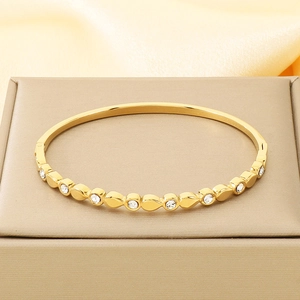 Detail of 18K gold plated stainless steel bracelet with teardrop metal and white zircon stones