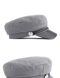 Detail of grey wool mariner cap featuring black leather brim and braided rope accent