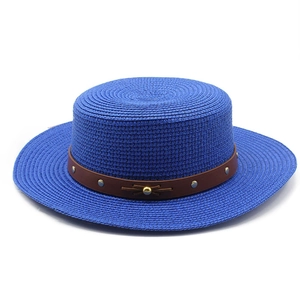 Détail d'un chapeau de paille bleu avec bande en cuir ornée de rivets métalliques