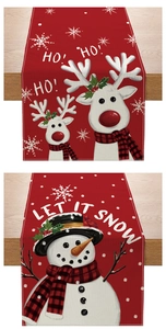Detail of red Christmas table runner featuring reindeer, snowman and holiday slogans