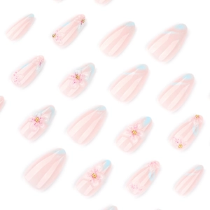 Faux ongles amande courts avec fleurs 3D et perles dorées sur dégradé rose tendre
