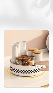 Close-up of rotating kitchen organizer tray with wood-lidded ceramic and glass storage jars
