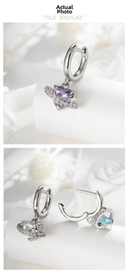Detail of heart-shaped planet earrings with zircon planetary rings in three colors