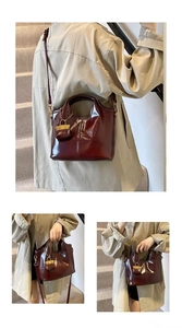 Detail of wine red oil wax leather tote featuring side padlock charm and detachable strap