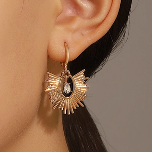 Boucles d'oreilles soleil doré avec zircon goutte d'eau sur un mannequin