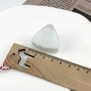 Detail showing white frosted glass hair clip size with wooden ruler measurement