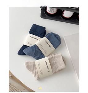 Close-up of ribbed texture and material detail of men's cotton crew socks in neutral tones