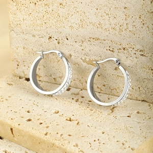 Detail of silver stainless steel hoop earrings with double row rhinestones on stone base