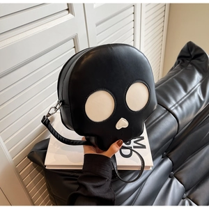 Detail of creative skull-shaped crossbody bag with white eye patches and heart nose