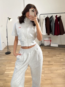 Light gray two-piece tracksuit with short-sleeved zip-up crop top and high-waist wide-leg pants
