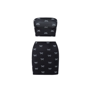 Detailed view of black two-piece set featuring silver bow patterns on tube top and skirt