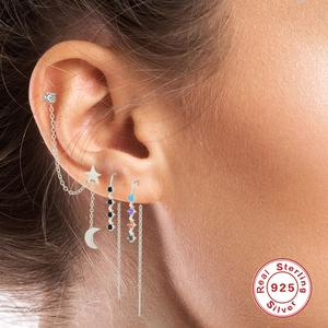 Detail of 925 sterling silver earring set with star moon charms and colorful stones
