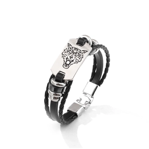 Close-up of men's leather bracelet featuring a silver metal plate with wolf head engraving
