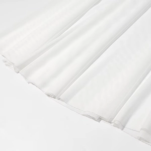 Close-up of white mesh fabric hem showing delicate texture and fine stitching details