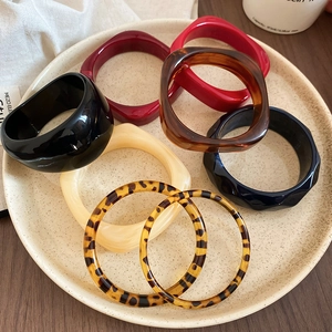 Collection of acrylic resin bangles with leopard print in a ceramic dish, vintage style
