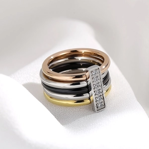 Detailed macro view of four-color stacked rings with a vertical five-stone crystal setting