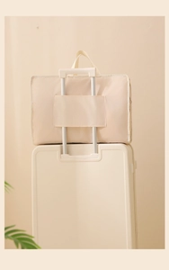Beige travel bag detail showing the convenient sleeve for suitcase trolley handles
