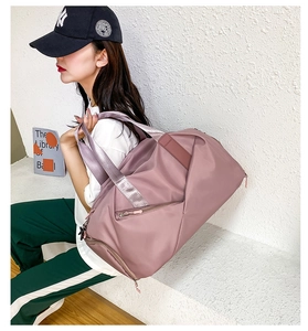 Pink large travel fitness bag with wet dry separation used by model on stairs