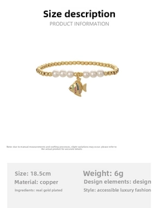 Detail of beaded bracelet with gold beads, white pearls and a colorful fish charm