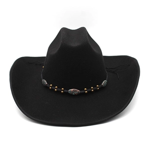Dettaglio del cappello da cowboy in feltro con fascia etnica e borchie turchesi