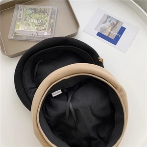 Detail of wool-like brown and black berets showing 100% polyester material label