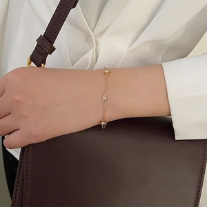 Minimalistisches goldenes Titanstahl-Armband mit Zirkonia, getragen am Handgelenk
